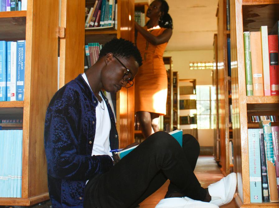 to afrikanere på et bibliotek, den ene læser